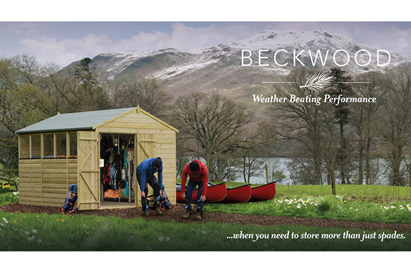 2 men putting on weatherproof clothes outside a weather-beating wooden shed