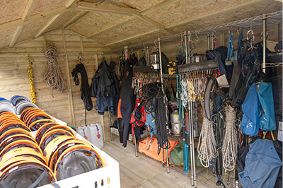 racks of climbing equipment inside a large reverse apex shed