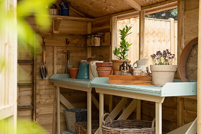 a potting bench underneath a window in a shed