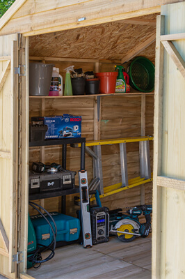 a photo took through the open doors of an apex shed showing shelves inside