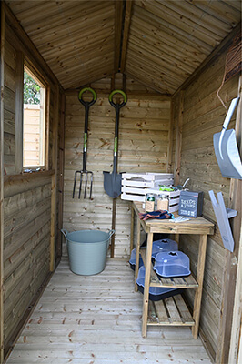 A small spex shed with tools hung up on the far wall