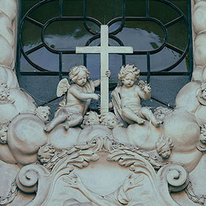 a sculpture of a cross and cherubs outside a church