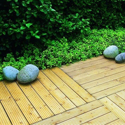 wooden deck tiles edged by greenery and stones