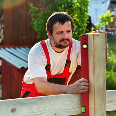 A man assembling a garden fence