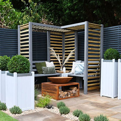 a corner arbour seat and tall, white planters