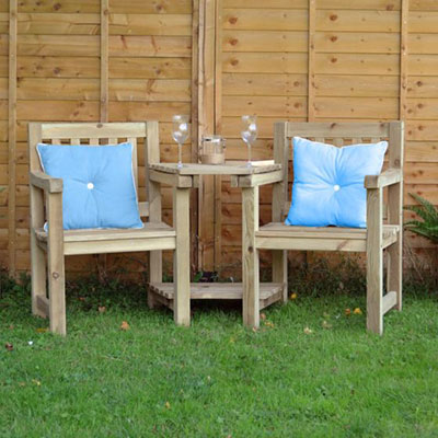 a wooden garden love seat with champagne flutes sat on the table