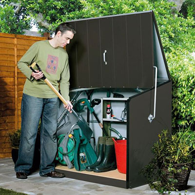 a man depositing a spade in an extra-strong and secure metal garden storage unit