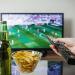 a remote control, television, beer and crisps