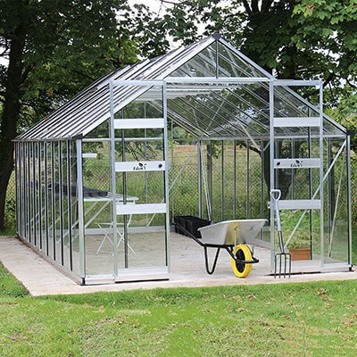 a large greenhouse with an aluminium frame and open double doors