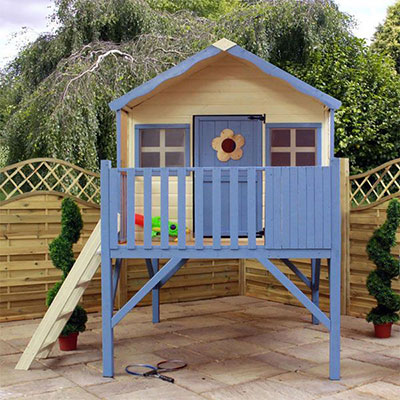 a cream and blue kids' playhouse on top a wooden tower, including a ladder