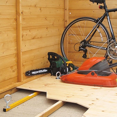 a bicycle, lawnmower and power tool, attached to a shed floor by an underfloor locking kit