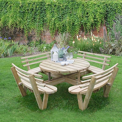 a wooden circular picnic table and 4 matching picnic benches