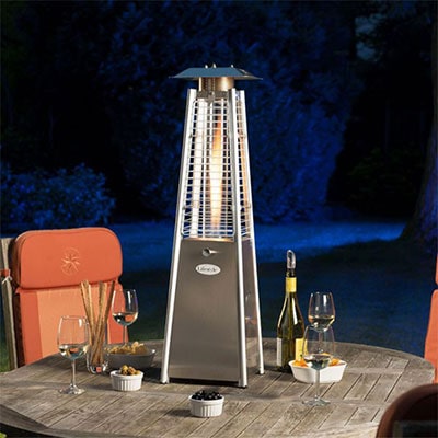A small outdoor heater on a wooden table, next to some wine glasses
