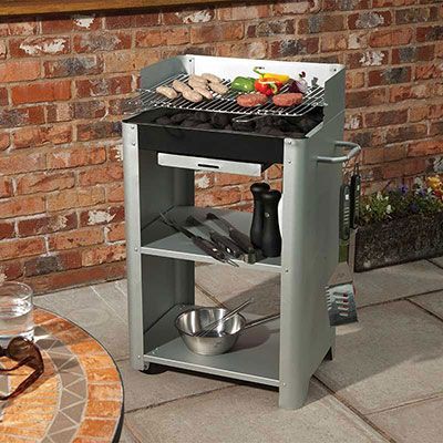 a variety of food on a deluxe charcoal BBQ, which includes an integral trolley