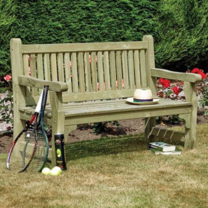 The Rowlinson Softwood Wooden Garden Bench, situated on a lawn, with a hat on the seat, tennis rackets to the side and a book underneath.