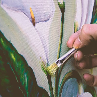a person painting a white flower