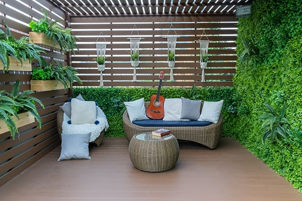 a secluded garden deck with slatted panel and lots of plants