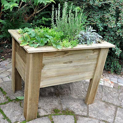A 3x2 wooden garden planter, containing plants and herbs