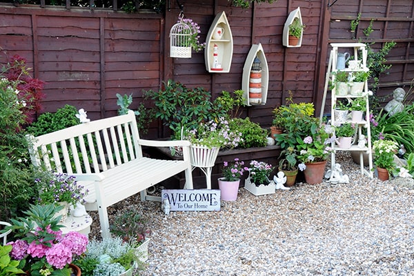 a garden bench next to a fence with lots of decorative accessories