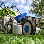 A blue lawnmower on a lawn.