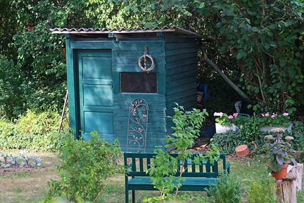 a small blue shed with a door and window